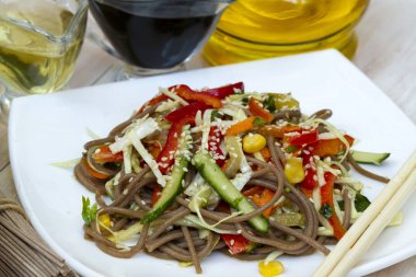 Sebze ve susam yakın çekim ile Japon soba salatası masada bir tabakta. erişte salatası. sebzeli karabuğday şehriye. vejetaryen Asya yemekleri. Sağlıklı vejetaryen gıda.