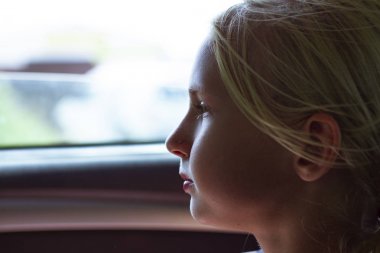 Rahat ve sakin bir araba yolcucloseup portre. Güzel bir genç sarışın kız arabada yolculuk tadını çıkarıyor. Kopya alanı. Arabayla seyahat edin. Hareketli bir otomatik penceresinde sevimli çocuk Portresi.