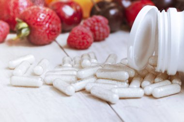 Olgun meyveler. Vejetaryen yemekleri. Besin takviyeleri. Taze vitamin beslenmesi. Doğal yemek. Detoks diyeti. Vücut bakımı. çilek ve meyve ile vitamin kapsül ve tablet. Taze meyve.