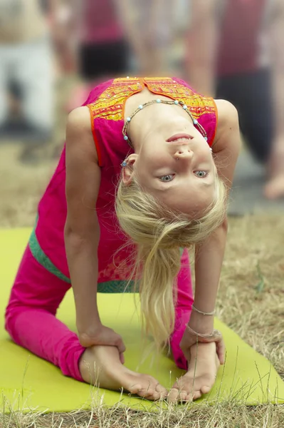 Kleine süße kaukasische Mädchen praktizieren Yoga-Pose auf Matte im Park. gesundes, bewegungsorientiertes Konzept. Kinder Yoga Konzept. Mädchen übt Yoga. Kind macht Übungen im Park. Gesunder Lebensstil. — Stockfoto