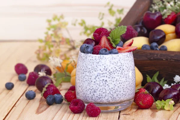 Chia seed pudding with berries on wooden table. rustic stile healthy Breakfast. Chia seed with milk, fruits and fresh berry. well being weight loss concept. yogurt drink, vitamin cocktail.