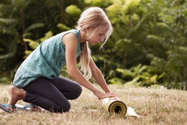 Sarışın beyaz kız haddeleme yoga mat. Yeşil yoga mat katlanır çekici genç kız yakın çekim. Sağlıklı yaşam tarzı. Sağlıklı, egzersiz konsepti. Çocuk yoga konsepti. kız yoga yapıyor.