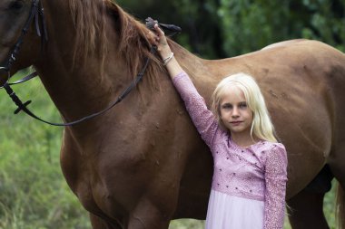 Hipster tarzı ve kahverengi at kız. ormanda kahverengi at ile pembe bir elbise güzel beyaz sarışın kız. doğal güzellik konsepti. Moda Illustration. masum çocukluk kavramı