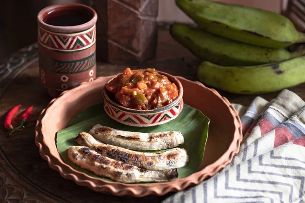 chili plantains with spicy tomato sauce. Healthy food concept. Traditional African and Nigerian cuisine. Selective focus. fried bananas plantains. african food. African cuisine called Boli and sauce.