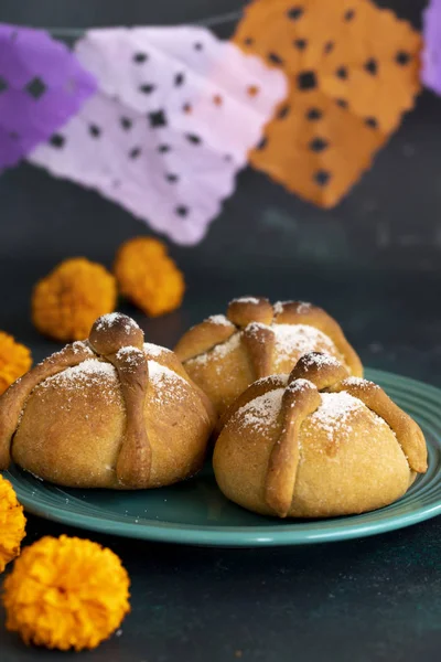 Mexican celebration, bread of death. Mexican parties with Dead bread and marigold flowers on gray stone background. Traditional Mexican Bread of the Dead Pan de Muerto .