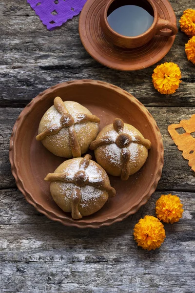 Mexican celebration, bread of death. Mexican parties Dead bread and marigold flowers on wooden rustic background. Traditional Mexican Bread of the Dead Pan de Muerto , Top view, Copy space.