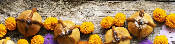 Mexican celebration banner, bread of death. Mexican parties Dead bread and marigold flowers on wooden rustic background. Traditional Mexican Bread of the Dead Pan de Muerto , Top view, Copy space.