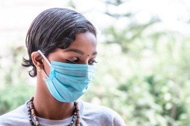 Koronavirüs. Koruyucu maske takmış güzel üzgün Afrikalı genç bir kızın portresi. Corona virüsü karantina konsepti, Covid-19. Stresli durum, nefsi müdafaa, kendini izole etme. Askerler!