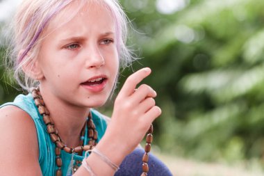 Sarışın, beyaz bir kız yaz günü tespihlerle mantra meditasyon yapıyor. Yoga, farkındalık, uyum konsepti - kız dışarıda karşılama jesti yapıyor. Yeşil yaşam tarzı. Yoga günü