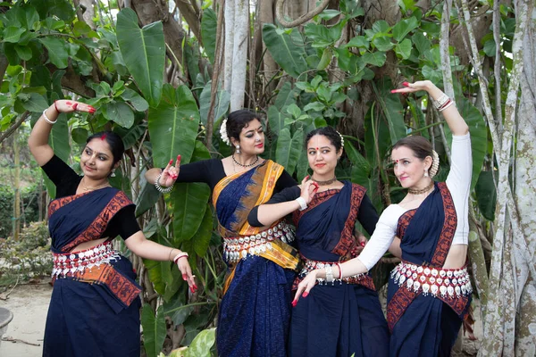 Grupo multinacional de hermosos jóvenes bailarines odissi clásicos lleva traje tradicional y posando mudra danza Odissi en la selva tropical . — Foto de Stock