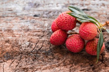 Tahta arka planda yaprakları olan Lychee. Tropikal meyve, köy tarzı, cjpy alanı, yakın çekim