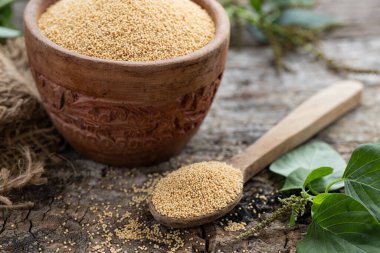 Rustik ahşap arka planda bir Bowl WitnAmaranth bitkisindeki çiğ Organik Amaranth Grain. Sağlıklı renkli glüten besin konsepti