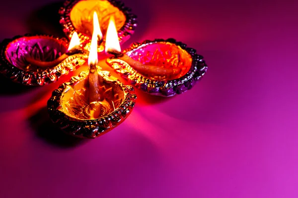 Brandende diya op Happy Diwali paarse achtergrond voor licht festival van India, kopieer ruimte — Stockfoto