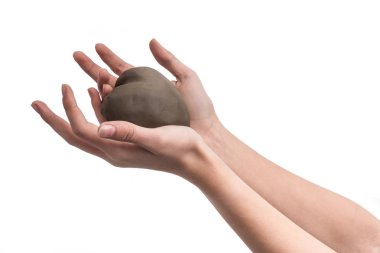 Çamurdan yaptım bir kalp tutan bir kızın el. Kavramsal görüntü whit elleri ve kalp. Sevgi ve sevgililer gün simgesi.