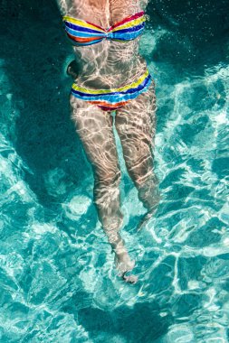 Genç kadın yüzme ve su havzasında rahatlatıcı.