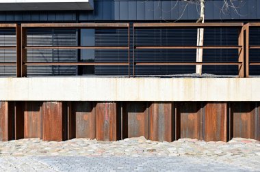 Beton duvarda metal çitler var.