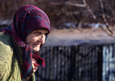 Yaşlı, yalnız bir kadın uzak görünüyor. Yoksulluk yaşlıyken olur