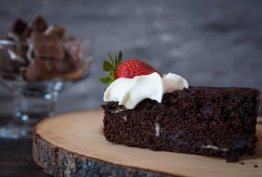 Çikolatamuz kek koyu arka plan üzerinde krema ile süslenmiş. Üstte görüntü