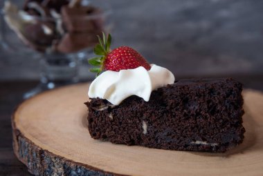 Çikolatamuz kek koyu arka plan üzerinde krema ile süslenmiş. Üstte görüntü