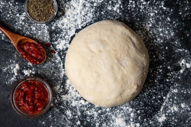 Çiğ hamur hazırlama veya malzeme ile pizza: domates sosu. Düz döşeme stili