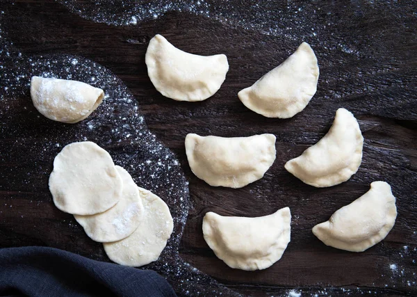 Rauwe knoedel met aardappelen. Voorbereiding dumplings op een zwarte BAC — Stockfoto