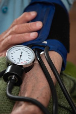 Yaşlı bir hastanın tansiyonunu ölçüyorum.
