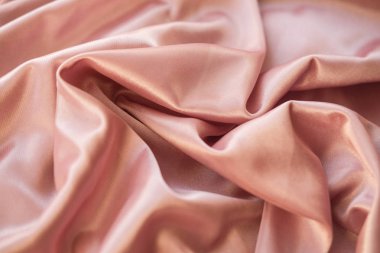 Kumaş kadar kapatın. İpek kumaş dalgalar atılır. Arka plan veya doku için pembe saten kumaş.                  