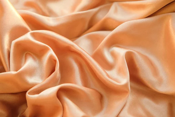 Fabric gold waves - material for background and texture. Close up fabric.