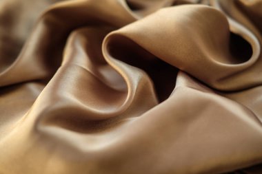 Altın kumaş dalgalar atılır. Saten kumaş. Kahverengi malzeme 