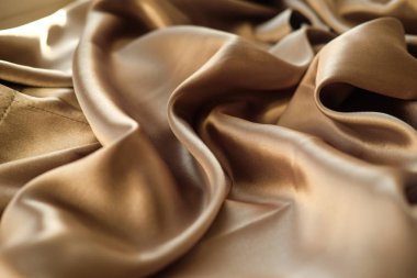 Altın kumaş dalgalar atılır. Saten kumaş. Kahverengi malzeme 