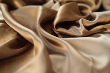 Altın kumaş dalgalar atılır. Saten kumaş. Kahverengi malzeme 