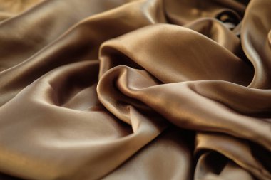 Altın kumaş dalgalar atılır. Saten kumaş. Kahverengi malzeme 