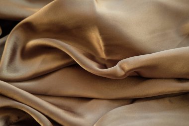 Altın kumaş dalgalar atılır. Saten kumaş. Kahverengi malzeme 