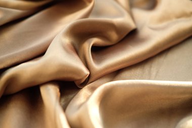 Altın kumaş dalgalar atılır. Saten kumaş. Kahverengi malzeme 