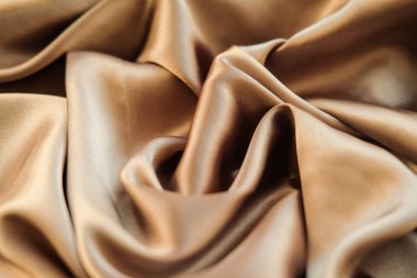 Altın kumaş dalgalar atılır. Saten kumaş. Kahverengi malzeme 