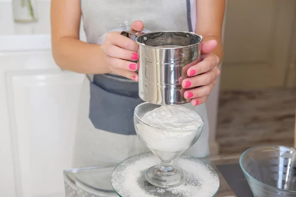 Young pastry cooker woman sift the flour and bake the cake in the modern kitchen.