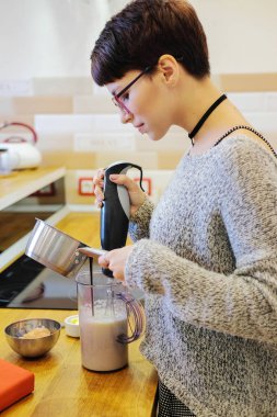 Kız bir karıştırıcı ile pişirme için çikolatalı hamur karıştırma. Tatlı yemek kadın portresi.