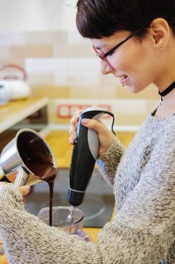 Kız bir karıştırıcı ile pişirme için çikolatalı hamur karıştırma. Tatlı yemek kadın portresi.
