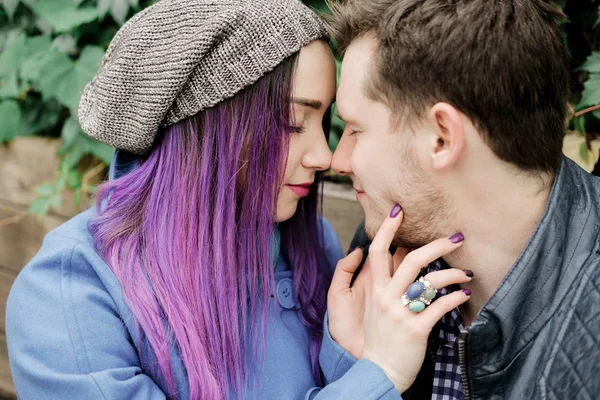 A couple is sitting in an embrace on in the street. Woman and man kissing.