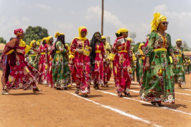 Renkli giyimli kadınlar, Ngaoundere 'de Kadınlar Günü boyunca bir şenlik geçidinde yürüyorlar. Gurur, birlik ve coşkulu kültürel sevinç yayıyorlar..