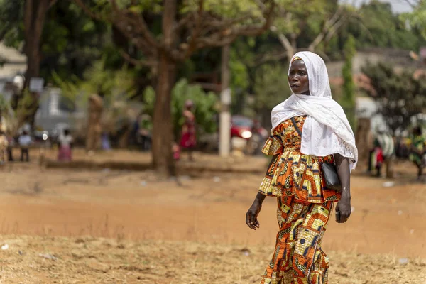 Afrikalı bir kadın, Ngaoundere 'de düzenlenen Uluslararası Kadın Günü' nde canlı geleneksel kıyafetler ve beyaz bir eşarp giyerek zarafetle yürüyor..