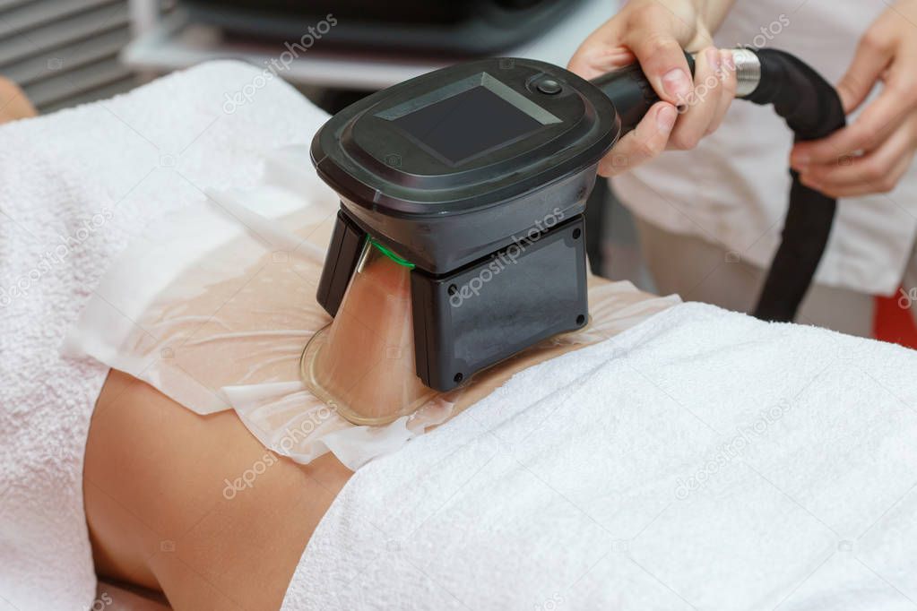 Woman getting cryolipolysis fat treatment procedure in professional cosmetic cabinet or spa center, closeup