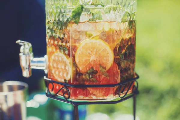 Citrus lemonade with mint in beverage dispenser. Catering service drinks on summer party