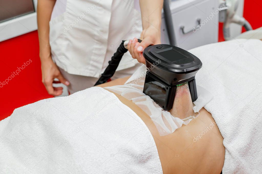 Woman getting cryolipolysis fat treatment procedure in professional cosmetic cabinet or spa center