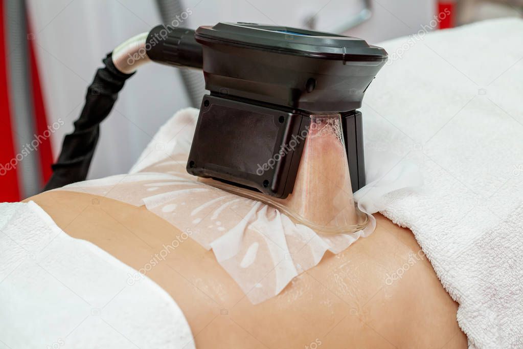 Woman getting cryolipolysis fat treatment procedure in professional cosmetic cabinet or spa center