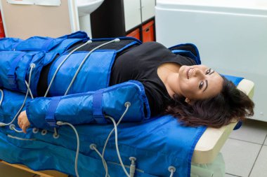 Gülümseyen güzellik merkezi pressotherapy makinede masaj anti selülit prosedürü sahip kadın