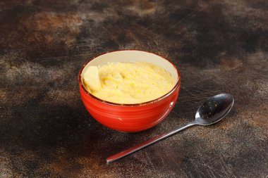 Buğday lapası ve kaşık, lezzetli kahvaltı kahverengi zemin üzerine kase