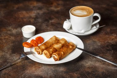 Sütlü kahve fincan süzme peynir ve kuru kayısı ile doldurulmuş krep