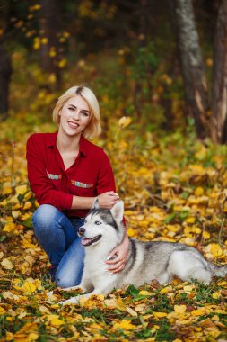 Güzel beyaz kız sonbahar orman veya park husky köpek ile çalış