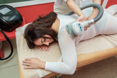Anti selülit lpg tedavi masaj terapisti ve cihazlar ile prosedürü kozmetik kliniğinde olan kadın